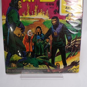 May include: A vintage comic book cover featuring a scene from the Planet of the Apes. The cover art depicts a group of apes in a jungle setting, with one ape holding a weapon. The text on the cover reads "Planet of the Apes" and "45 RPM YR-21".