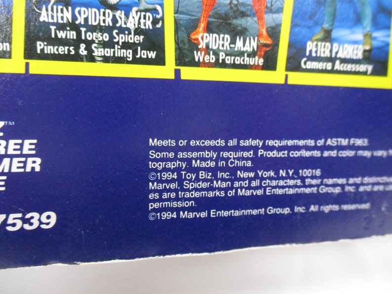 Pu&ograve; includere: Una carta blu e gialla con il testo "Alien Spider Slayer" e "Twin Torso Spider" in un riquadro giallo. Il testo "Pincers & Snarling Jaw" &egrave; anche nel riquadro giallo. La carta presenta anche immagini di Spider-Man e Peter Parker.