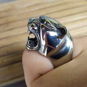 May include: A silver ring featuring a detailed design of a snarling panther head.