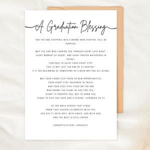 May include: A white graduation card with the words "A Graduation Blessing" in elegant script. The card contains a heartfelt message of encouragement and congratulations for the graduate, with a brown envelope.