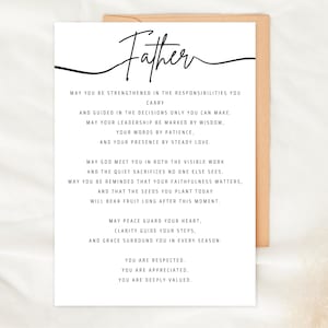 May include: A white card with the word "Father" in elegant script, accompanied by a heartfelt message. The card is set against a neutral background, suggesting a thoughtful gift for a father figure.