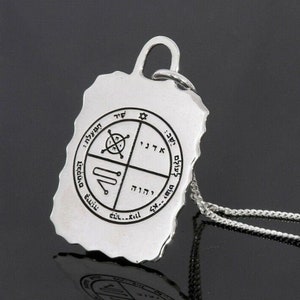 May include: A silver pendant necklace with a rectangular charm and a silver chain. The charm has an irregular edge and features engraved symbols and text in a circular pattern. The pendant is approximately 1.5 inches in length.