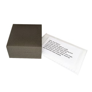 Puede incluir: Una peque&ntilde;a caja cuadrada marr&oacute;n con un pa&ntilde;o blanco en su interior. El pa&ntilde;o tiene un mensaje impreso que dice: "&iexcl;Hola, estimado comprador! Te enviamos este pa&ntilde;o como regalo. Est&aacute; hecho espec&iacute;ficamente para limpiar tus joyas preciosas y es perfecto para pulir tus cadenas, dijes y anillos. Luce y si&eacute;ntete lo mejor posible mientras usas tus hermosas joyas limpias"
