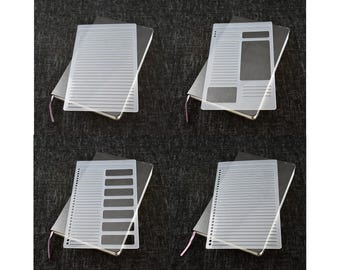 Puede incluir: Cuatro plantillas de plástico transparente para cuaderno, cada una con un diseño diferente. Las plantillas se colocan sobre cuadernos cerrados con cubiertas negras.