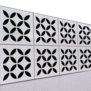 May include: A wall of white ceramic tiles with a black geometric pattern. The pattern is made up of overlapping circles that create a flower-like design.