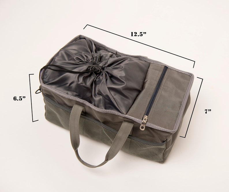 May include: A gray canvas tote bag with a drawstring top and a zippered pocket. The bag has two handles and measures 12.5 inches wide, 6.5 inches tall, and 7 inches deep.