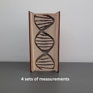 May include: A book with pages carved to display a DNA double helix design. The book has a brown cover and the pages are light-colored. The DNA design is dark brown. The book is standing upright.