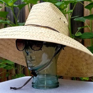 Straw hat jumbo Nat. size maximum sun coverage approximately 21" x 21" great for anything under the sun, with a strap.  head size 24" in.