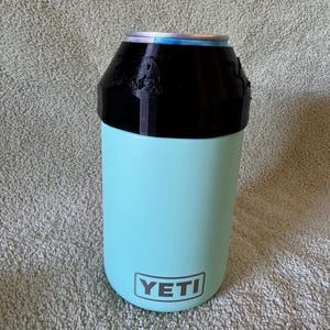 Red Bull 8.4oz Lid & can with Newer Quick Turn YETI colster can cooler (type 2) made for 12oz standard cans. Prancing Bull version shown in black.