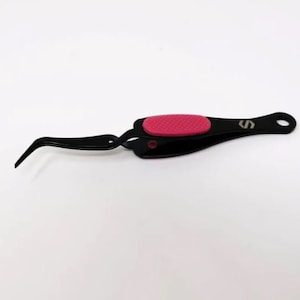 May include: Black tweezers with a pink rubber grip. The tweezers have a curved tip and a small hole at the end of the handle.