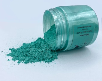 May include: A 2 oz jar of teal mica powder spills out onto a white surface. The jar is labeled "Premium Mica Powder, Non-Toxic, 2 oz Grams, ParticleArtSupplies.com".