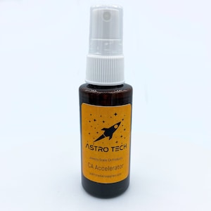 Puede incluir: Una botella marrón con una boquilla de pulverización blanca y una etiqueta amarilla. La etiqueta tiene un cohete negro y estrellas, y el texto "ASTRO TECH Jewelry Grade CA Products CA Accelerator patrickkadairsuplies.com".