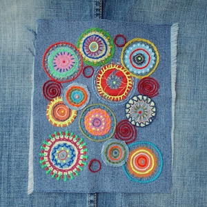 Grote, met de hand gestikte en geborduurde denim patch voor jeans. Zichtbare reparaties, boho-versiering; boho-applicatie om op te naaien met onafgewerkte randen.