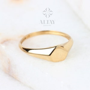 May include: A gold signet ring with a flat, hexagonal top.