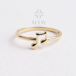 May include: A gold musical note ring. The ring is simple and elegant, with a delicate musical note design.