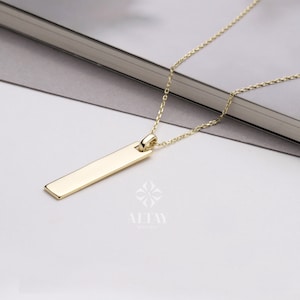 May include: A gold chain necklace with a rectangular pendant. The pendant is smooth and has a polished finish.