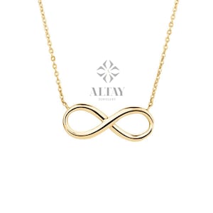 May include: A gold infinity necklace with a delicate chain. The necklace is a symbol of eternal love and friendship.