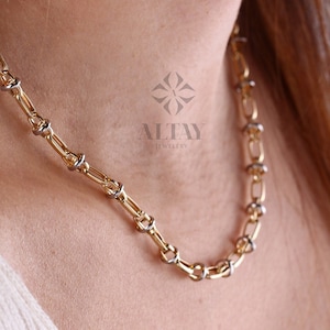 May include: A gold chain necklace with alternating oval and round links. The round links are made of white metal.