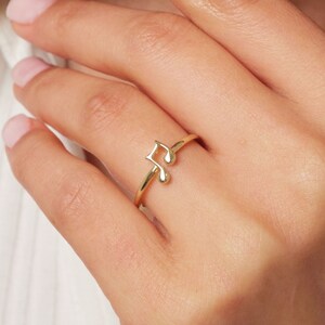 May include: A gold ring with a music note design.