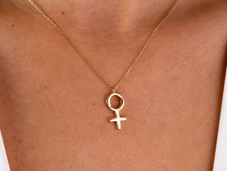 K&ouml;nnte beinhalten: Eine goldene Kettenkette mit einem Anh&auml;nger in Form des weiblichen Symbols.