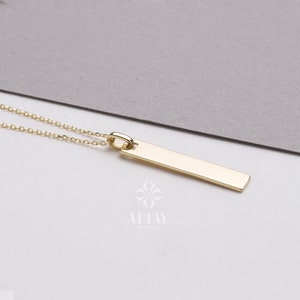 May include: A gold bar pendant necklace with a delicate chain. The pendant is a simple, rectangular shape.