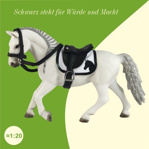 Ein weißes Schleich Pferd mit einem Sattel und einer Trense in Schwarz.