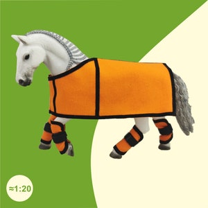 Schleich Pferd mit Decke und Gamaschen in Orange.