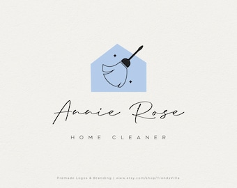 May include: A logo design featuring a blue house shape with a black and white cleaning mop inside. The name "Annie Rose" is written in elegant script, with "HOME CLEANER" below in a simple font. The background is a light beige.