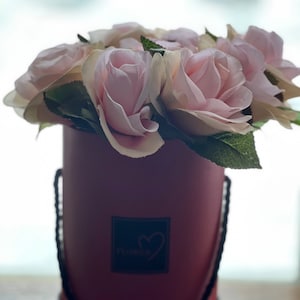 fausses roses dans une boîte de chapeau