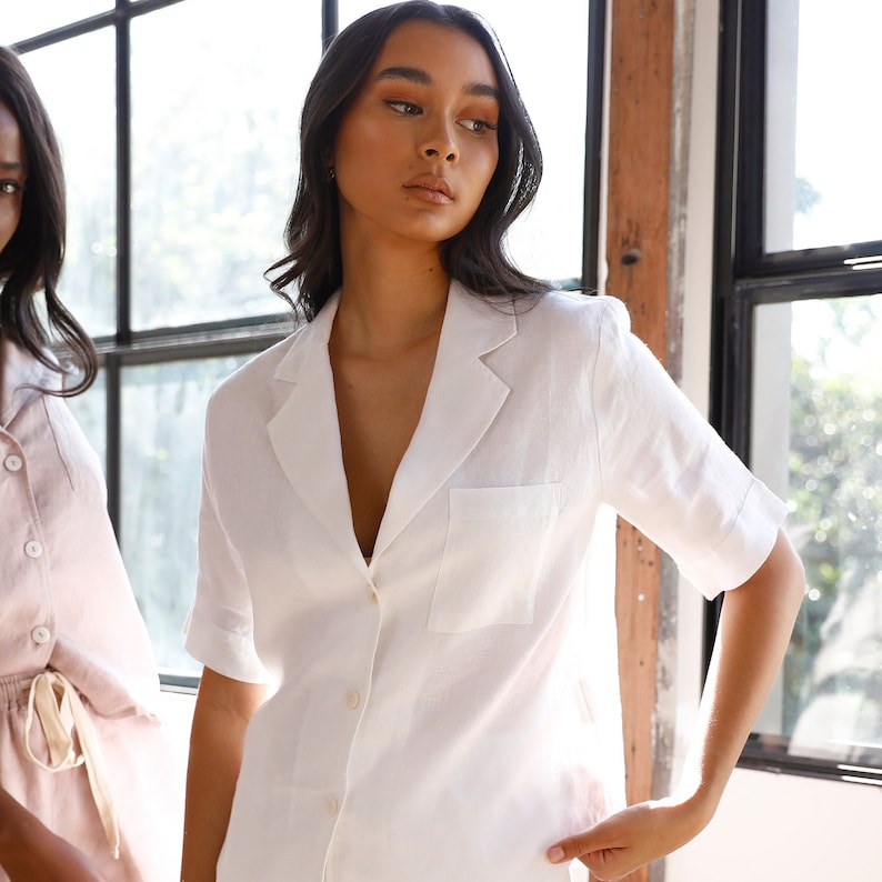 May include: A white linen shirt with a collar, a button-up front, and a single pocket on the left chest.