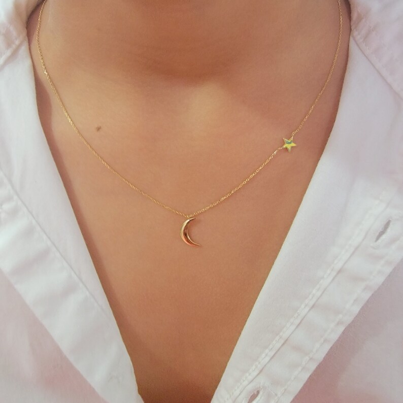 May include: A gold chain necklace with a crescent moon charm and a star charm