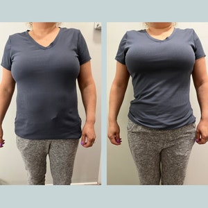 Puede incluir: Una mujer con una camiseta azul oscuro de cuello en V y pantalones de chándal grises.