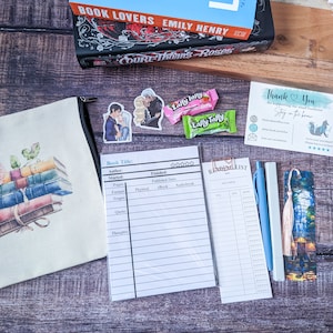 May include: A reading list printable with a book stack illustration on a beige canvas pouch, a bookmark with a blue and white illustration, a blue pen, a pink and white Laffy Taffy candy, and a thank you card with a fox illustration.