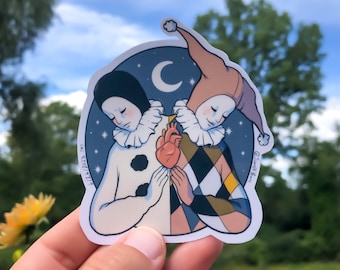 May include: A sticker featuring two stylized clowns, one in black and white and the other in colorful harlequin patterns, holding a red heart between them. The background is a dark blue night sky with a crescent moon and stars.