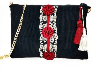 Black velvet clutch bag with silk flowers.