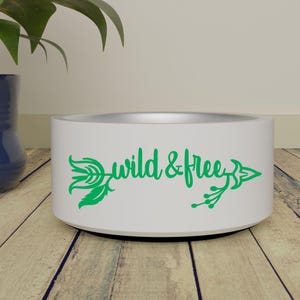 May include: White ceramic pet bowl with a green arrow and the text "wild & free" printed on the side.
