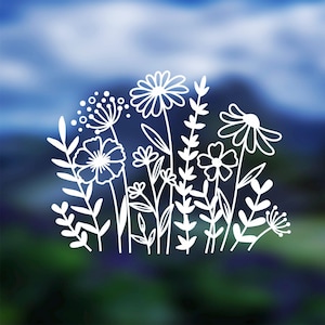 May include: White line art of various wildflowers and foliage against a blurred blue and green background. The design features detailed outlines of daisies, other flowers, and leaves, creating a delicate, natural aesthetic.