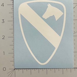 May include: White vinyl decal of the 1st Infantry Division patch. The patch features a white horse's head facing left, with a white diagonal stripe across a white shield.