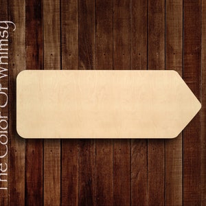May include: A wooden arrow sign with a rounded top and a pointed tip. The sign is blank and ready to be painted or decorated. The sign is made of natural wood and has a light brown color.