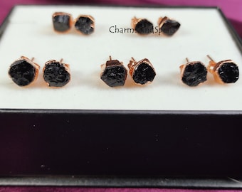 May include: Six pairs of black gemstone earrings with rose gold settings. The earrings are displayed in a white box with the text "Charms and Spells" on the top.