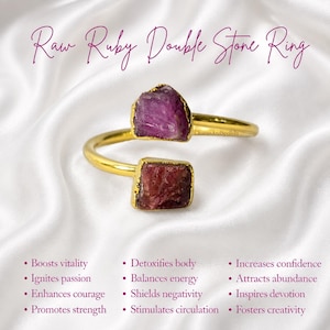 May include: A gold-toned open ring featuring two raw, uncut ruby stones. The text "Raw Ruby Double Stone Ring" appears at the top, with a list of benefits including "Boosts vitality," "Ignites passion," "Enhances courage," and "Promotes strength" below.