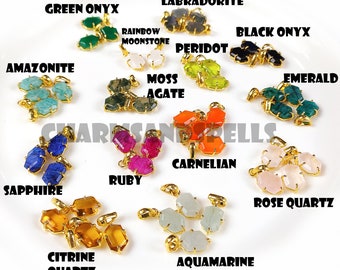 Puede incluir: Surtido de colgantes de piedras preciosas con engastes dorados. Las piedras incluyen: ónix verde, labradorita, piedra lunar arcoíris, peridoto, ónix negro, amazonita, ágata musgosa, esmeralda, zafiro, rubí, cornalina, cuarzo rosa, cuarzo citrino y aguamarina.