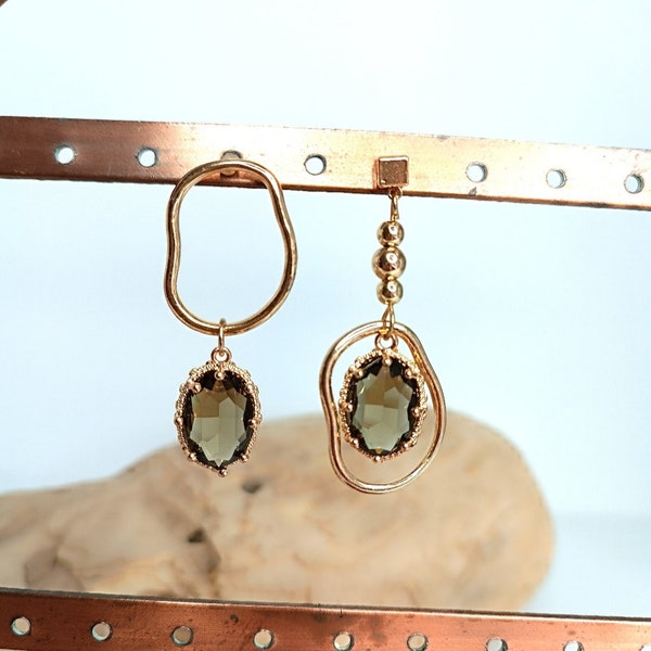 Boucles d'oreilles pendantes asymétriques avec pierres de cristal et finition dorée