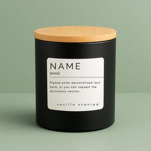 May include: A black candle with a wooden lid. The candle has a white label with the word "NAME" and the text "Please enter personalised text here, or you can request the dictionary version. vanilla scented."