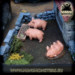 Può includere: Scena in miniatura con tre maiali rosa in un recinto. Due maiali sono in piedi vicino a una mangiatoia di legno piena di cibo, mentre un altro è sdraiato sulla schiena. Il recinto è circondato da muri di pietra.