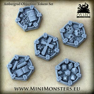 Puede incluir: Un conjunto de fichas de juego hexagonales grises con varios diseños, incluyendo calaveras, una cruz y barriles. Cada ficha tiene un número en su borde. El texto "Ambergrad Objectives Tokens Set" está en la parte superior. El logotipo y el sitio web de Mini Monsters también son visibles.