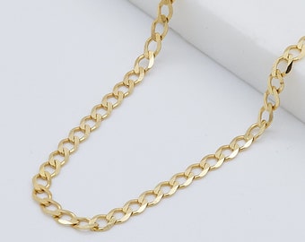 May include: A gold chain necklace with a curb link style. The chain is on a white surface.