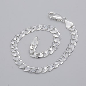 May include: A silver curb chain bracelet with a lobster clasp.