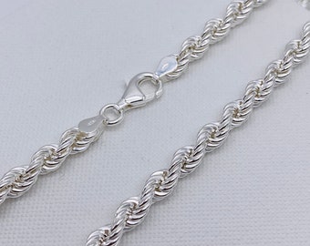 May include: A silver rope chain necklace with a lobster clasp closure.