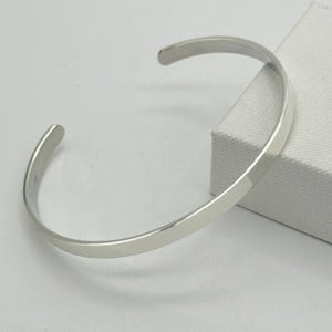Peut inclure: Un bracelet jonc en argent simple avec une finition lisse et polie.